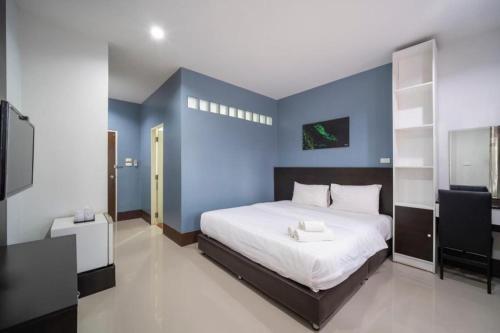 a bedroom with a bed with a blue wall at Belleville hotel in Phetchabun