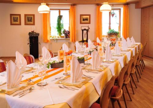 a long table with white tablecloths and napkins at Landhotel Grüner Baum in Westendorf