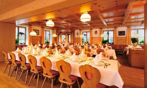 a large banquet hall with white tables and chairs at Landhotel Grüner Baum in Westendorf