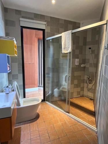 a bathroom with a shower and a toilet and a sink at Read River in Anping