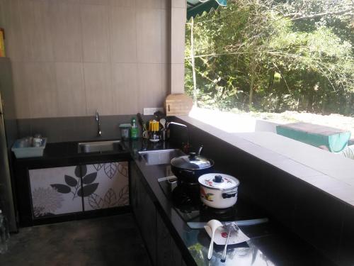 Elle comprend une petite cuisine avec un évier et une fenêtre. dans l'établissement Green Peace Sungai Lembing, à Sungai Lembing