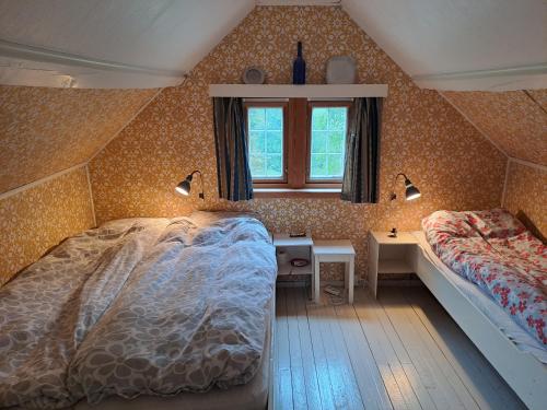 a bedroom with two beds and a desk and a window at The Old Cabin in Vikedal