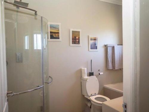 a bathroom with a toilet and a glass shower at Silver Pond Lodge in Robertson
