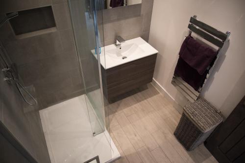 a bathroom with a sink and a glass shower at Dun Caan Apartment in The Braes