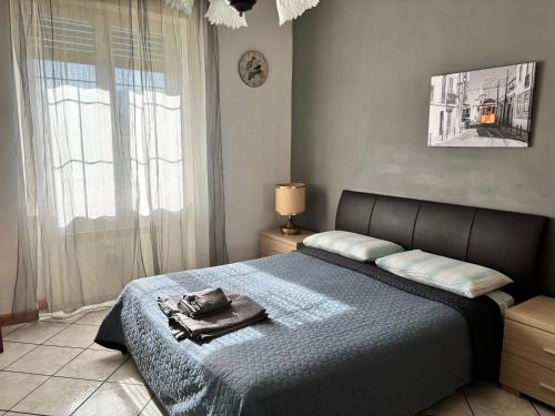 a bedroom with a bed with a blue blanket and a window at Avventura e Relax a Bagnasco 1 in Bagnasco