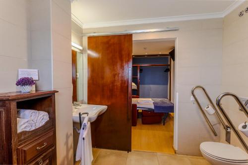 a bathroom with a sink and a toilet and a bed at Casa Do Vale Hotel by Umbral in Évora