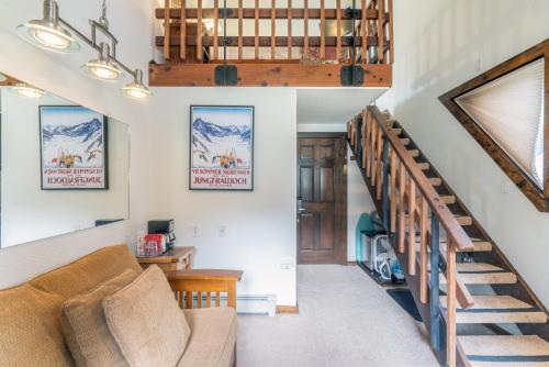 a living room with a couch and a staircase at Manitou Lodge 11 by Alpine Lodging Telluride in Telluride