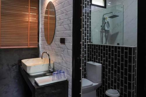 a bathroom with a sink and a toilet and a mirror at S Garden View Resort in Ban Bang Yai Chuai