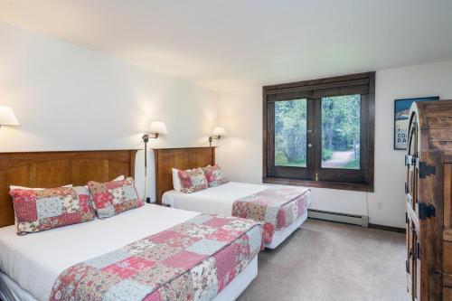 a bedroom with two beds and a window at Manitou Lodge 2 by Alpine Lodging Telluride in Telluride