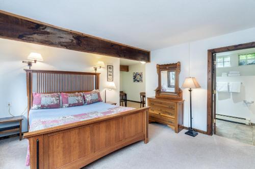 a bedroom with a large wooden bed and a mirror at Manitou Lodge 4 by Alpine Lodging Telluride in Telluride
