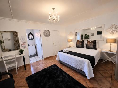 a bedroom with a bed and a table and a mirror at Zhantique Guest House 1- Unit 5 in Boksburg