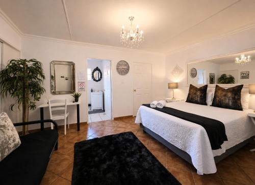 a bedroom with a large bed and a table at Zhantique Guest House 1- Unit 5 in Boksburg