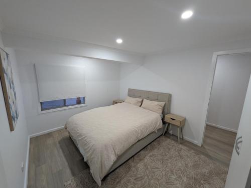 a white bedroom with a bed and a window at Private Coastal Sanctuary Beachside Escape in Bunbury