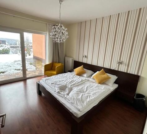 a bedroom with a large bed and a chandelier at BlueBird Apartments in Latschach