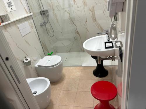 a bathroom with a toilet and a sink and a shower at Corsica Rooms in Termoli