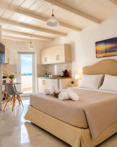 a bedroom with a large bed and a kitchen at Crystal Suites in Mikonos