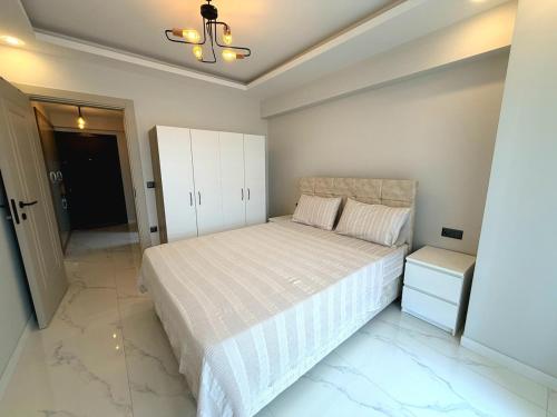 a bedroom with a white bed and a white cabinet at Dalaman Airport Suite 11 in Dalaman