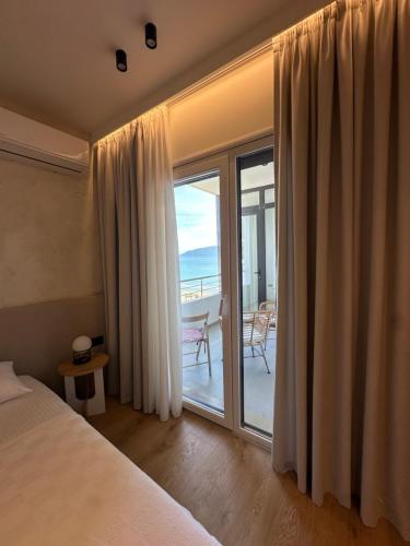 a bedroom with a bed and a sliding glass door at Lungomare ViewPoint in Vlorë