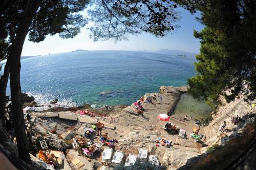 a group of people sitting on a cliff near the ocean at Gorgeous apartment Dora in Cavtat