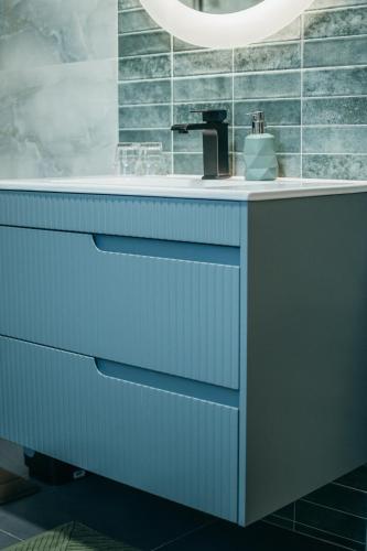 a bathroom with a blue vanity with a sink at Kormos Residence in Brăduţ