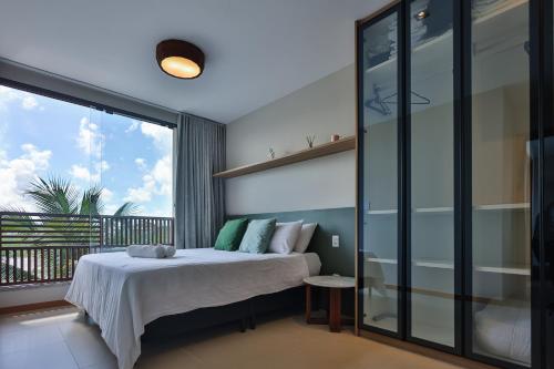 a bedroom with a bed and a balcony at Condominio Frente Mar 3 suites com Ar Cond piscina e Hidro privativa in Mata de Sao Joao