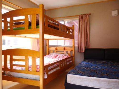 a bedroom with two bunk beds and a bed at Guest House Tomida in Ena