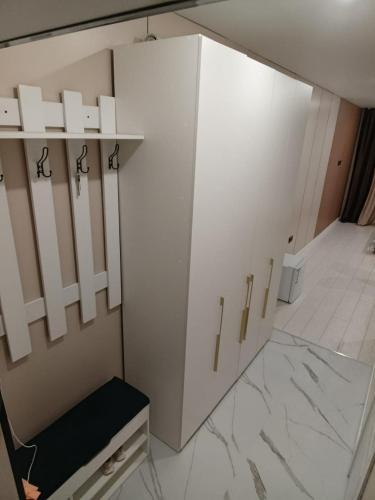 a dressing room with white cabinets and a black chair at ЖК Akjol in Astana