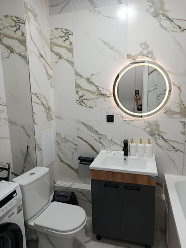 a bathroom with a toilet and a sink and a mirror at ЖК Akjol in Astana