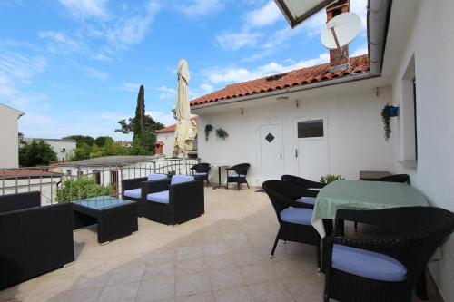 a patio with chairs and a table on a balcony at Rooms and Studio Salvi in Rovinj