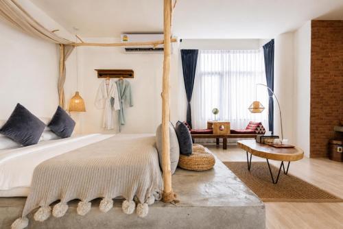 a bedroom with a canopy bed and a living room at YOLO Bangkok Boutique Hotel in Bangkok