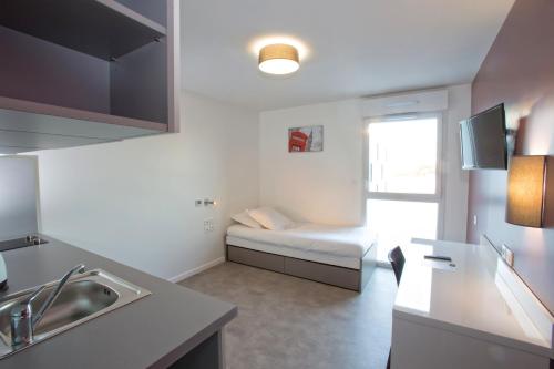 a kitchen with a couch and a bed in a room at All Suites Appart Hôtel - Bordeaux - Pessac in Pessac