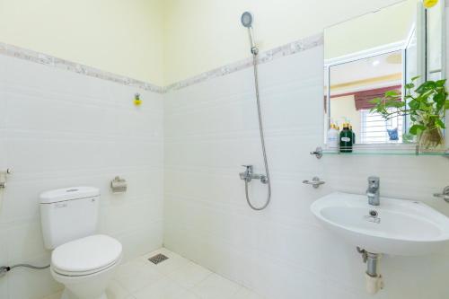 a white bathroom with a toilet and a sink at Villa Long Cung B2-9 in Vung Tau