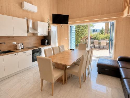 a kitchen and dining room with a wooden table and chairs at Vila Porto Olive Heated Pool near Piran & Portorož in Portorož