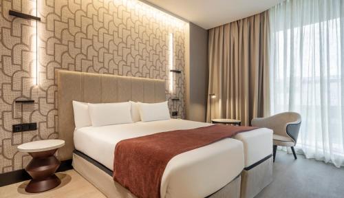 a hotel room with a bed and a chair at Ilunion Atrium in Madrid
