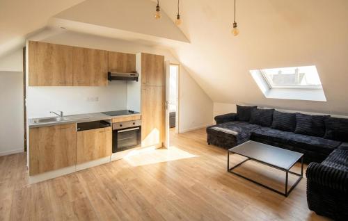 a living room with a couch and a kitchen at Appartement Proche Touquet in Étaples