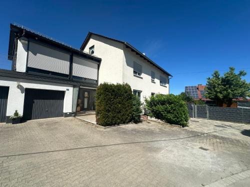 a large white house with a driveway in front of it at Haselbach Living in Ehekirchen