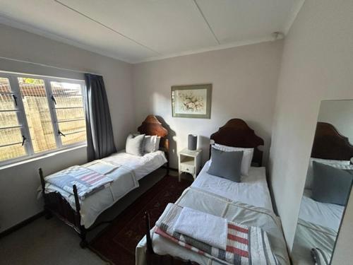 a bedroom with two beds and a window at 13 bedford street in Grahamstown
