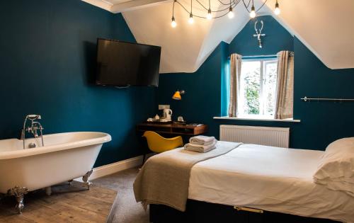 a bedroom with a tub and a bed and a window at The Jacobean Hotel in Coventry
