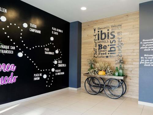 a room with a wall with a sign on it at Ibis Oviedo in Oviedo