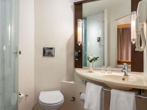 a bathroom with a sink and a toilet and a mirror at Ibis Kayseri in Kayseri