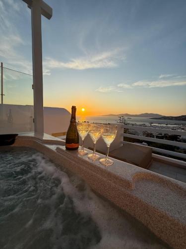 a hot tub with wine glasses and a bottle of wine at Ibiscus Boutique in Mikonos