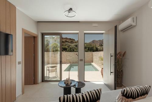 a living room with a view of a swimming pool at Increteblue Suites in Plakias