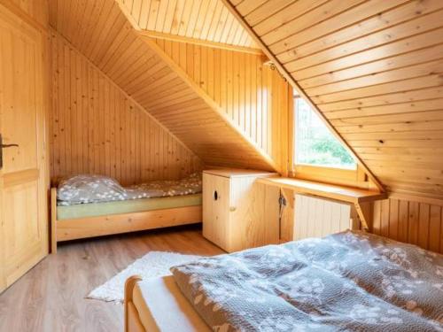 a room with a bed in a wooden cabin at Domki u Teresy in Dębno