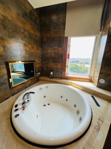 a large white tub in a bathroom with a window at Walker Motel 2 in Taipei