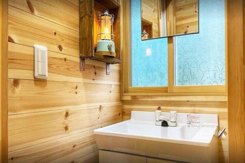 a bathroom with a white sink and a window at イーリス軽井沢 in Naganohara