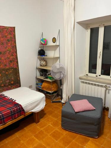 a bedroom with a bed and a chair and a fan at Casa Belvedere in Mazzano Romano