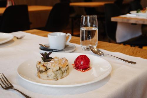 a plate with a pastry and a strawberry on a table at Schloss Freudenfels in Eschenz