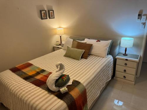 a bedroom with a bed with a stuffed swan on it at The Sanctuary on William - Nature Reserve Hideaway in Ormiston