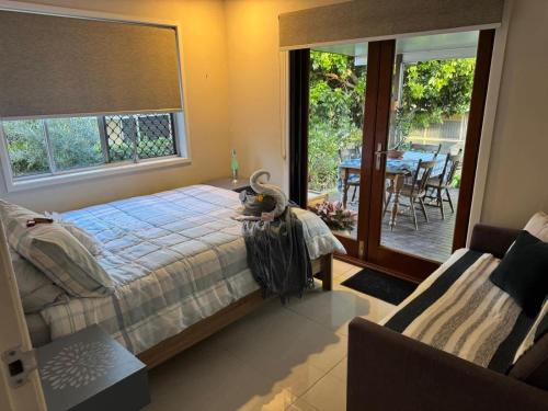 a bedroom with a bed and a table with chairs at The Sanctuary on William - Nature Reserve Hideaway in Ormiston
