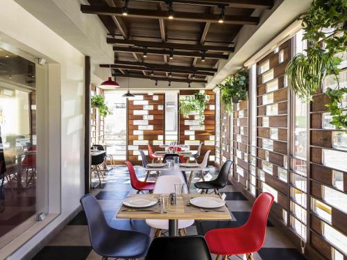 a restaurant with tables and chairs in a room at Ibis Chihuahua in Chihuahua